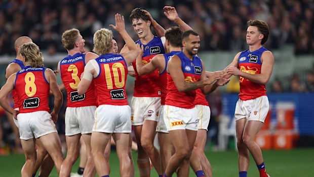 Brisbane Lions players celebrate a goal.