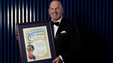 Jason Dunstal holds his Australian Football Hall of Fame certificate.