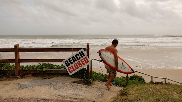 Former professional surfer Danny Wills heads out at main beach in Byron bay before the arrival of Cyclone Alfred.