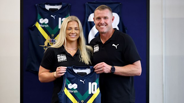 Ava Usher of the AFL National Academy is presented her jumper by Tarkyn Lockyer.