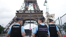 French police officers patrol the Eiffel Tower ahead of Paris 2024.