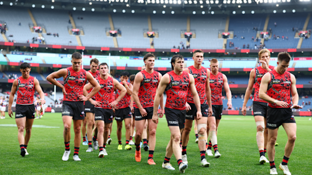 Essendon players leave a mostly empty MCG after losing to Freo.