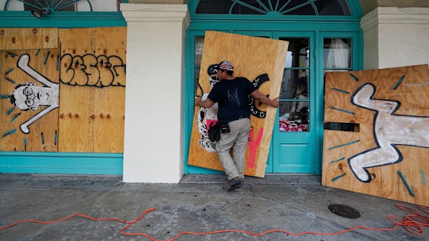 In preparation of Hurricane Ida, a workers attach protective plywood to windows and doors of a business in the French Quarter in New Orleans, Saturday, August 28, 2021. (AP Photo/Eric Gay)