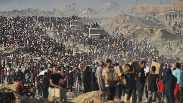 FILE - Palestinians carry sacks and boxes of food and humanitarian aid, unloaded from a World Food Program convoy that was heading to Gaza City in the northern Gaza Strip, Monday, June 16, 2025. (AP Photo/Jehad Alshrafi, file)