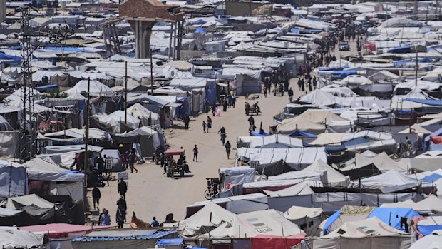 Displaced Palestinians walk through a makeshift tent camp in the Muwasi area of Khan Younis, in the Gaza Strip, on Monday, May 5, 2025. (AP Photo/Abdel Kareem Hana)