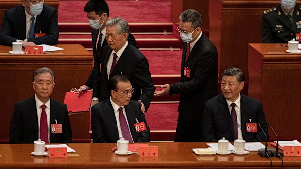 Chinese President Xi Jinping and Premier Li Keqiang, left, and Politburo member Wang Yang look on as former President Hu Jintao, centre, speaks to them as he is helped to leave early from the closing session of the 20th National Congress of the Communist Party of China.