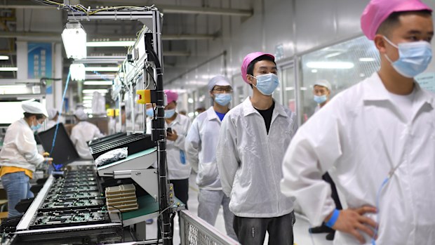 Workers line up to get tested for COVID-19 at the Foxconn factory in Wuhan in central China's Hubei province in August 2021.