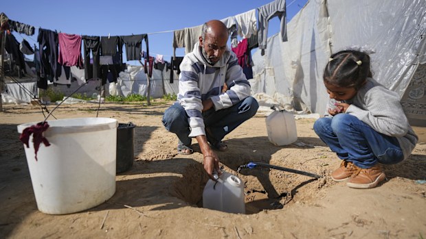 Ne'man Abu Jarad collects water as he and his family prepare to go back to their home in the north, at a camp for displaced Palestinians in the Muwasi area, southern Gaza Strip.