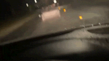 Two young people appear to use escooters to power a couch down a dark, wet Canberra street on May 3.