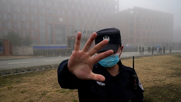 A security person moves journalists away from the Wuhan Institute of Virology after a World Health Organisation team arrived for a field visit in Wuhan in China's Hubei province in February 2021.