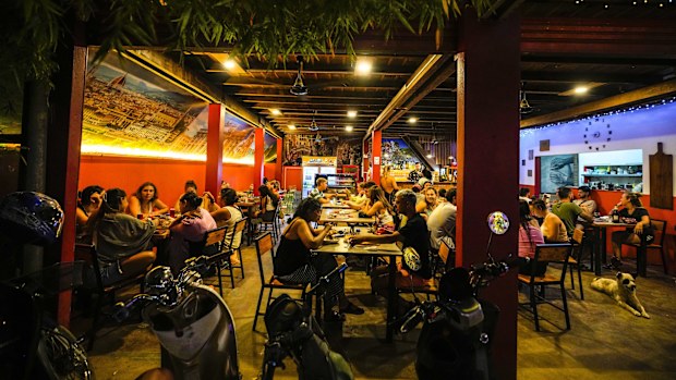 Tourists have drinks and pizza at a restaurant in Vang Vieng, Laos.