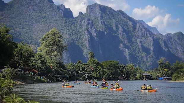 Tourists ride on kayaks in Namsong river in Vang Vieng, Laos.