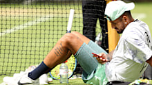 Nick Kyrgios checks his phone whilst on the Wimbledon practice courts.