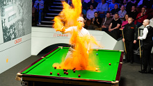 A Just Stop Oil protester jumps on the table and throws orange powder during the match between Robert Milkins against Joe Perry during day three of the Cazoo World Snooker Championship at the Crucible Theatre, Sheffield. Picture date: Monday April 17, 2023. (Photo by Mike Egerton/PA Images via Getty Images)