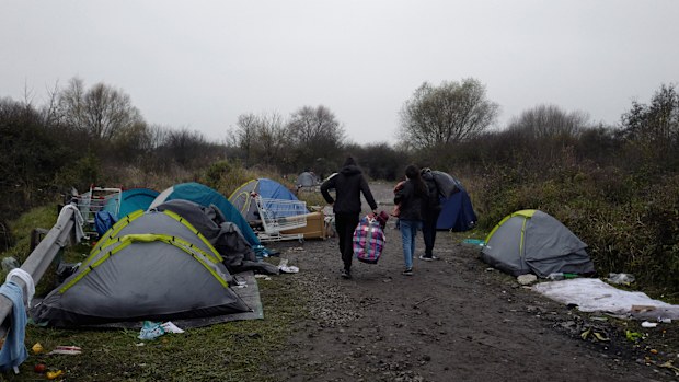 A migrants makeshift camp is set up along the river in Loon Plage, near Grande-Synthe, northern France, Friday, Nov. 26, 2021