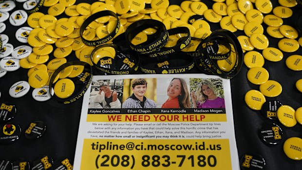 A flyer seeking information about the killings of four University of Idaho students who were found dead is displayed on a table along with buttons and bracelets on Nov. 30, 2022, during a vigil in memory of the victims in Moscow, Idaho.