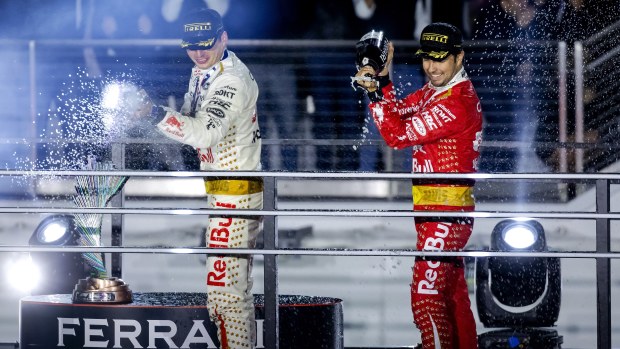 Max Verstappen and Sergio Perez celebrate on the podium after the Las Vegas Grand Prix.