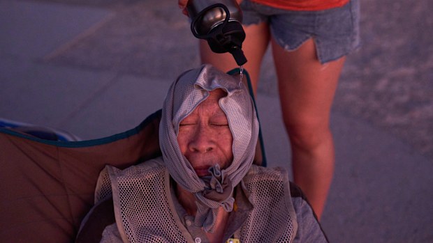 FILE - Grace Chyuwei pours water on Joe Chyuwei to help with the heat Aug. 3, 2025, in Death Valley National Park, Calif. (AP Photo/John Locher, File)
