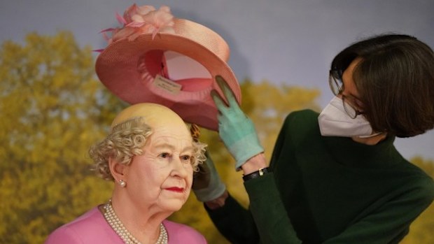 The wax figure of Queen Elizabeth II is bald underneath her hat.