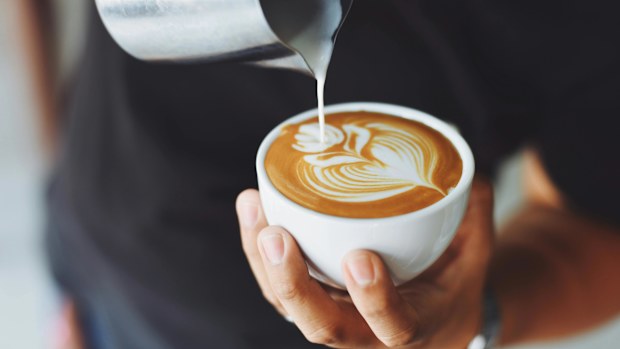 Stock image of a barista pouring a coffee.