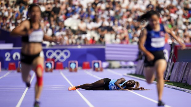 Lucia Moris of Team South Sudan is carried off the track by the medical staff during Women's 100m Preliminary Round on day seven of the Olympic Games Paris 2024 at Stade de France on August 02, 2024 in Paris, France 