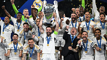 Nacho of Real Madrid lifts the Champions League trophy after his team's victory.