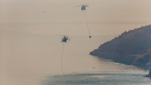 Helicopters fill monsoon buckets from Lyttelton Harbour, south of Christchurch.
