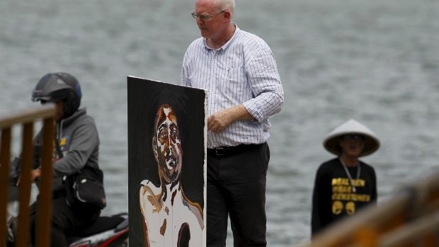 Lawyer Julian McMahon carries a self-portrait painted by Myuran Sukumaran, after visiting the prison island of Nusakambangan.