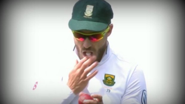 Faf du Plessis seen rubbing the ball with a mint in his mouth.