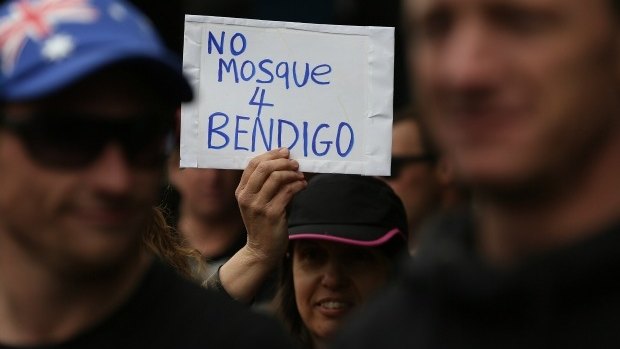 A woman holds a sign during an anti-mosque rally in August 2015.