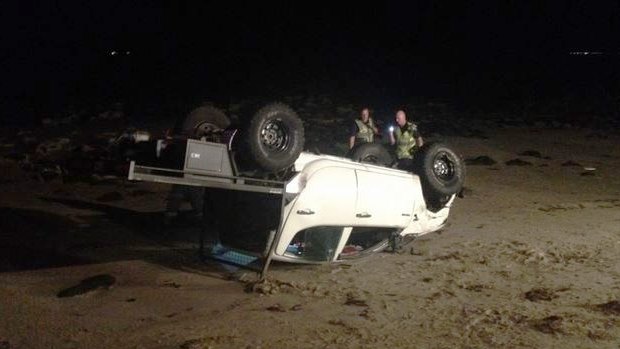 The 4WD landed on its roof after crashing through the seawall and injuring three people on Altona Beach. 