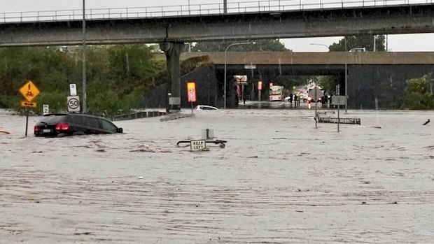 Cars are swept away outside Toombul shopping centre,