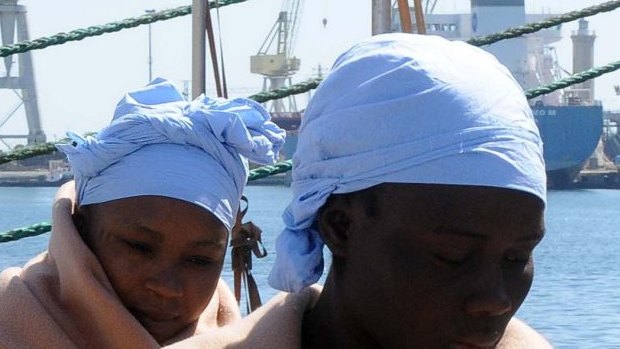 Asylum-seekers arrive in Palermo, Sicily, last week. In the background is the King Jacob Portuguese cargo vessel, the first ship to arrive near a boat believed to be crowded with 700 migrant in distress, only to see it capsizing in the waters north of Libya on Sunday.