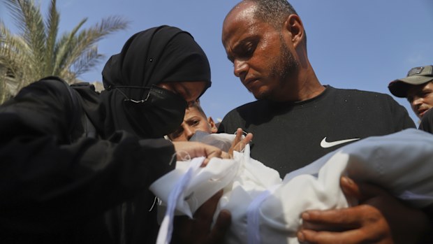 Ahmed Abu Halib and his wife Esraa Abu Halib, left, mourn over the body of their 5-month-old baby, Zainab, who died from malnutrition-related causes, according to the family and the hospital, during her funeral outside the Nasser Hospital, in Khan Younis, Gaza Strip, Saturday, July 26, 2025. (AP Photo/Mariam Dagga)