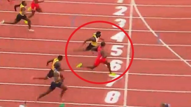 Noah Lyles (kırmızı tişört) Kenny Bednarek'e bakarak bitiş çizgisini geçiyor.