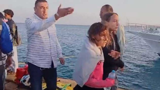 Survivors of the yacht sinking move to safety.