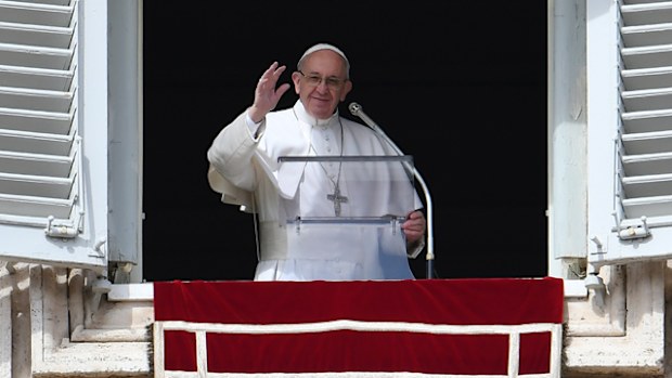 Pope Francis waves to the crowd from the window of the apostolic palace during the Sunday Angelus prayer, on March 5, 2017 at St Peter's square in Vatican. 