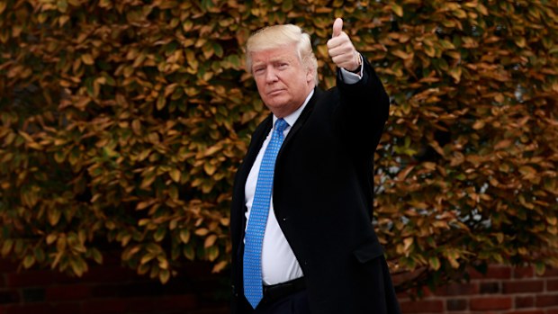 President-elect Donald Trump waves as he arrives at Trump International Golf Club for a day of meetings in Bedminster Township, New Jersey. 