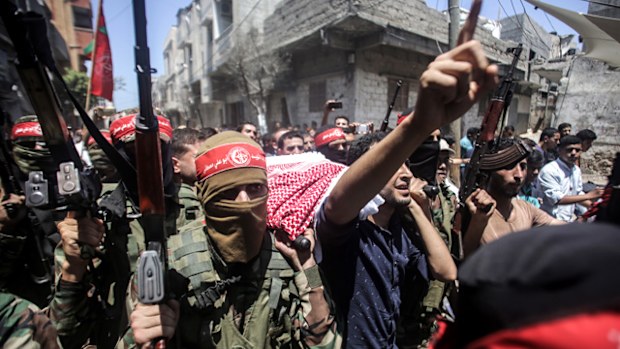 Palestinian mourners and armed men carry the body of Ayman al-Najjar during his funeral in Jabaliya refugee camp in the northern Gaza Strip. (AAP)