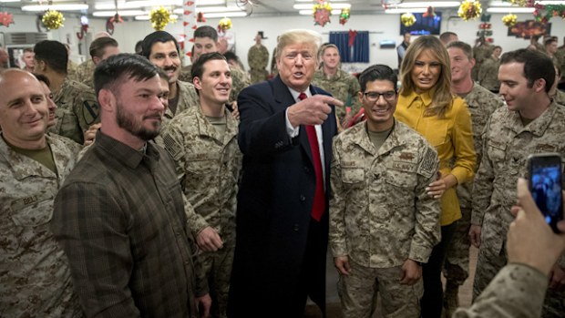 President Donald Trump and first lady Melania Trump pose for a photograph as they visit members of the military at a dining hall at Al Asad Air Base, Iraq