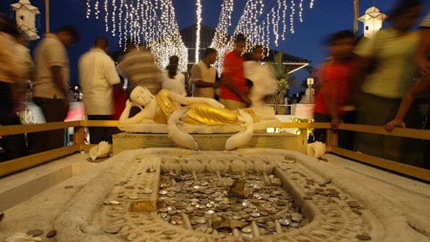 Sri Lankan Buddhist devotees make offerings beside a a statue of Prince Siddhartha, Child hood name of Load Buddha, as they commemorate Buddha Poornima at a Buddhist temple in Colombo, Sri Lanka