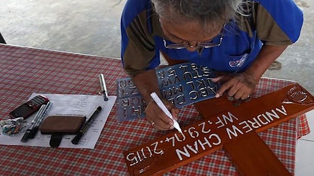 Mortician B. Suhendroputro stencils a cross for Andrew Chan. (Supplied)