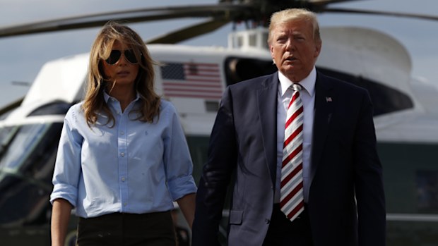 President Donald Trump, with first lady Melania Trump, walks towards the media.