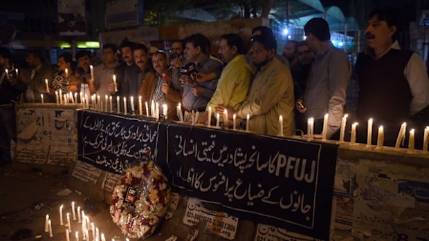Pakistani journalists light candles for the victims of an attack by Taliban gunmen on a school in Peshawar. (Getty)