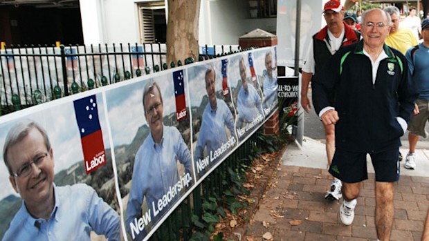 John Howard walks past some Kevin Rudd posters in 2007. (AAP)
