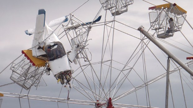 The pilot can be seen inside the light plane that crashed into a ferris wheel in Taree. (AAP)