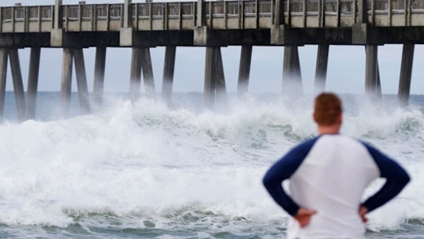 A man watches waves crash near the beach as a subtropical approaches the Florida coast. (Photo: AP).