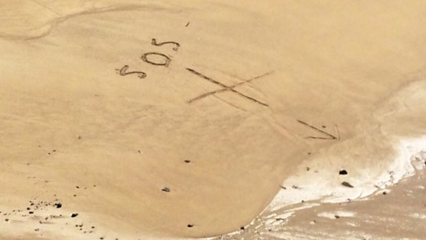 The 'SOS' message written in the sand. (RACQ CQ Rescue)