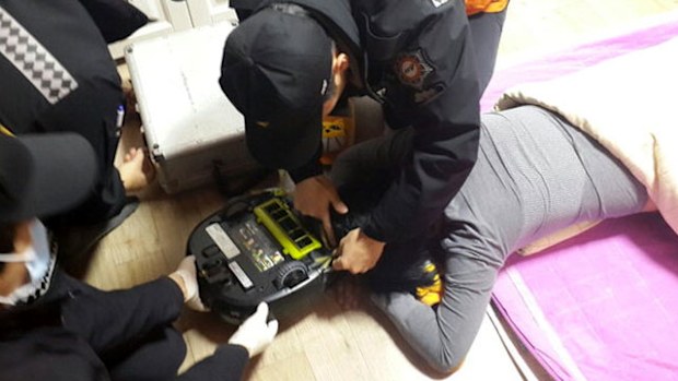 Emergency workers separating the woman from her vacuum cleaner. (Photo: Changwon Fire Department)