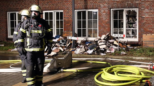 Firefighters outside the fire-bombed building of that houses the 'Hamburger Morgenpost'. (AAP)